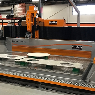 BACA Systems Edge stone saw dressed in orange and black machine decals